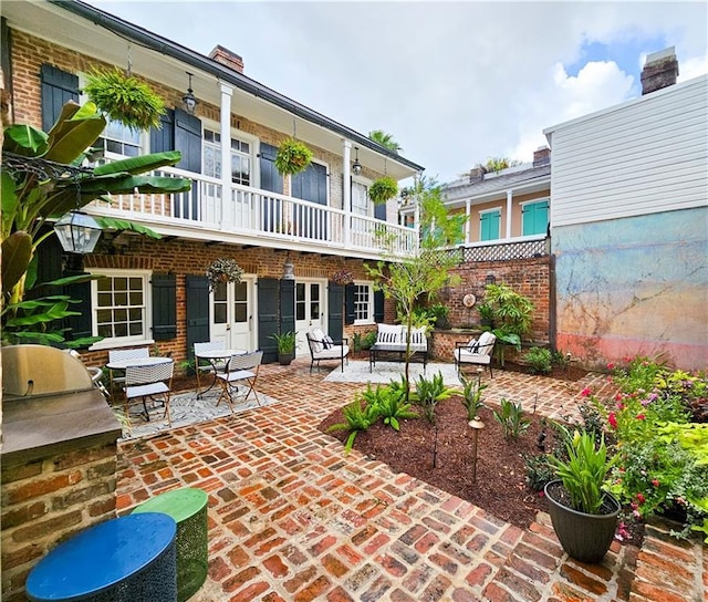 rear view of house with a patio, a balcony, and exterior kitchen