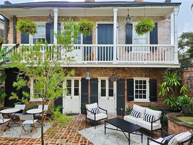 back of property featuring a balcony and a patio