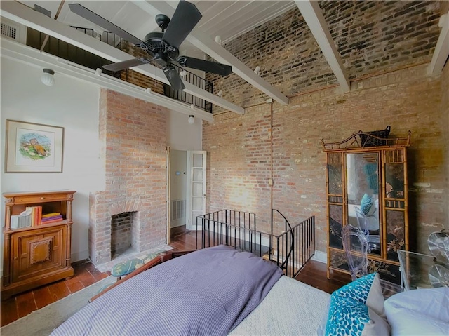 bedroom featuring a fireplace, brick wall, hardwood / wood-style flooring, beamed ceiling, and a high ceiling