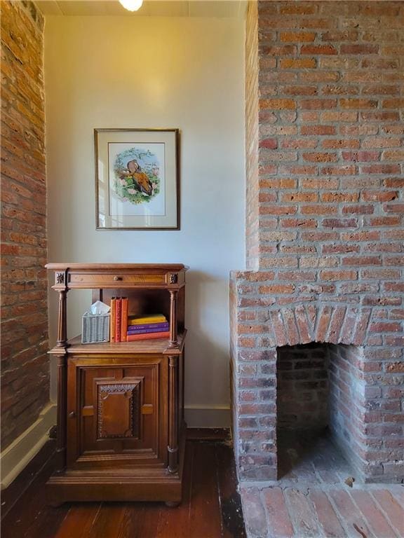 details with wood-type flooring and a brick fireplace