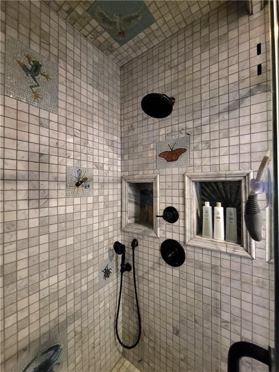 bathroom with tiled shower and tile walls