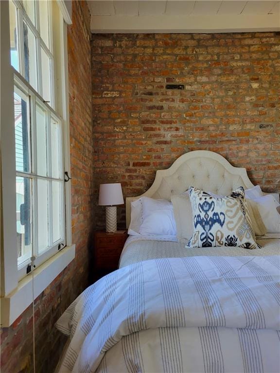 bedroom featuring brick wall