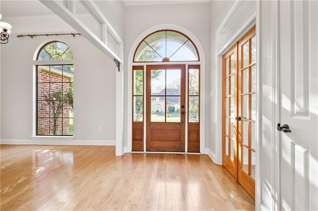 doorway to outside with french doors, crown molding, and light hardwood / wood-style floors