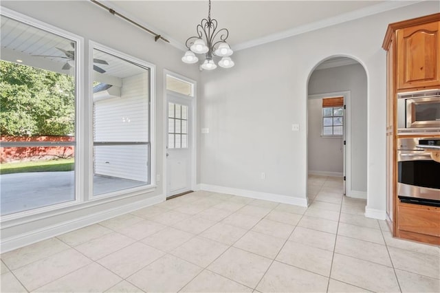 unfurnished dining area with ceiling fan with notable chandelier, ornamental molding, and light tile patterned floors