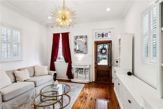 living room with an inviting chandelier, a wealth of natural light, ornamental molding, and dark wood-type flooring