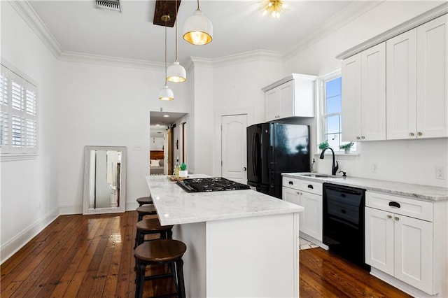 kitchen with pendant lighting, a center island, sink, black appliances, and dark hardwood / wood-style flooring