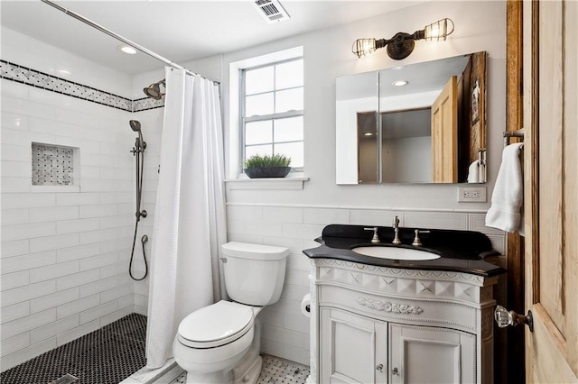 bathroom featuring tile walls, curtained shower, vanity, toilet, and tile patterned floors