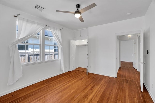 unfurnished bedroom featuring ceiling fan, hardwood / wood-style flooring, and a closet