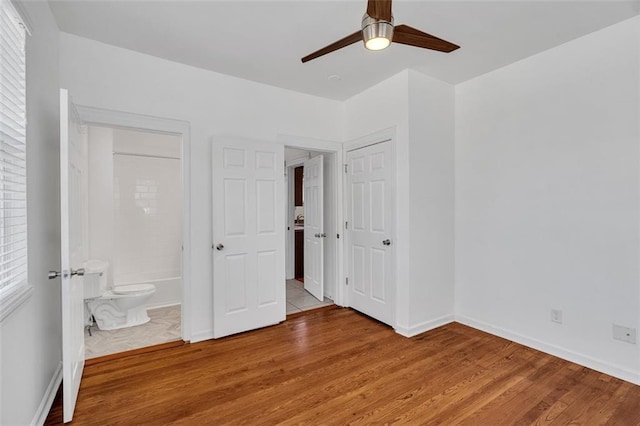 unfurnished bedroom with ceiling fan, light hardwood / wood-style flooring, a closet, and ensuite bath