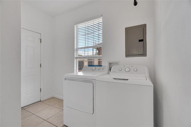 laundry room with washer and clothes dryer, light tile patterned flooring, and electric panel