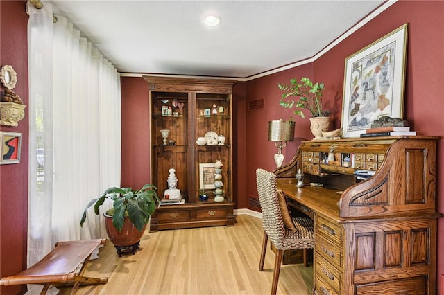 home office featuring light wood-type flooring and crown molding