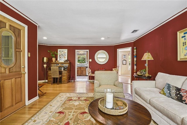 living room with light wood-type flooring and crown molding