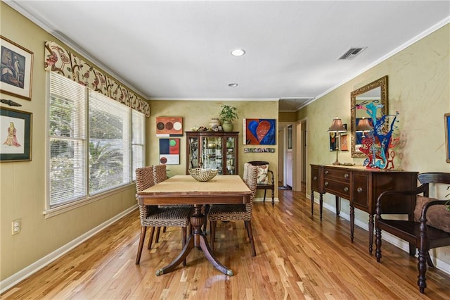 dining area with light hardwood / wood-style flooring and crown molding