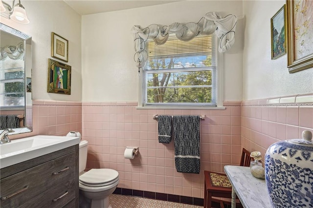 bathroom with toilet, a wealth of natural light, tile patterned flooring, and tile walls