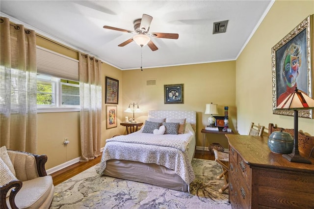 bedroom with ornamental molding, hardwood / wood-style floors, and ceiling fan