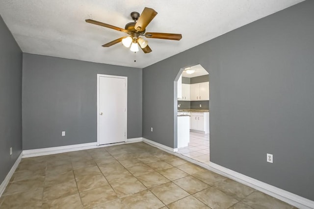 tiled spare room with ceiling fan