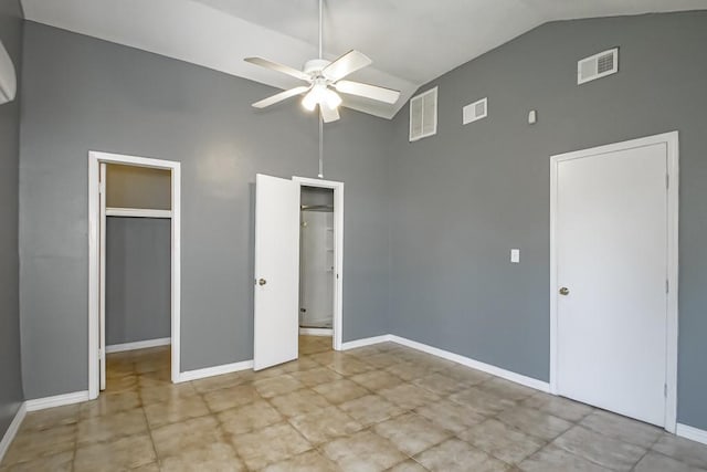 unfurnished bedroom with a closet, ceiling fan, a walk in closet, and high vaulted ceiling