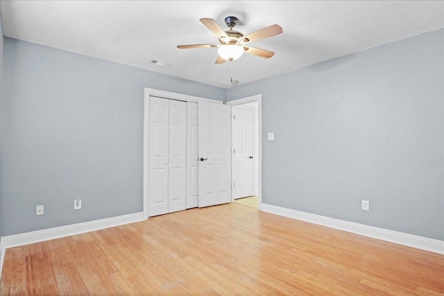 unfurnished bedroom featuring a closet, light wood-type flooring, and ceiling fan