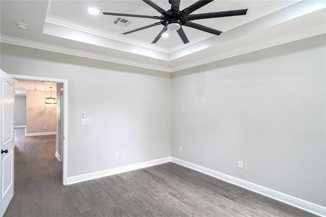 spare room with ceiling fan, a raised ceiling, ornamental molding, and dark hardwood / wood-style flooring