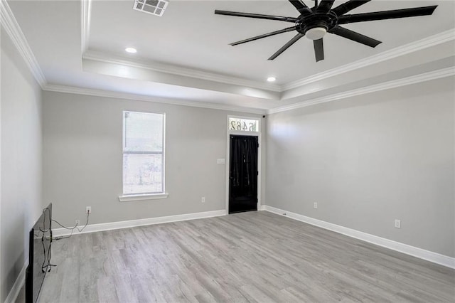 spare room featuring light hardwood / wood-style flooring, ceiling fan, a raised ceiling, and crown molding