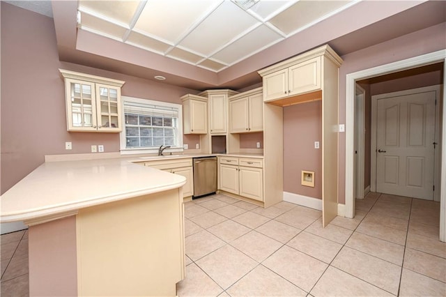 kitchen with dishwasher, kitchen peninsula, light tile patterned flooring, and cream cabinetry