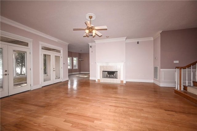 unfurnished living room with ornamental molding, ceiling fan, light hardwood / wood-style floors, and french doors