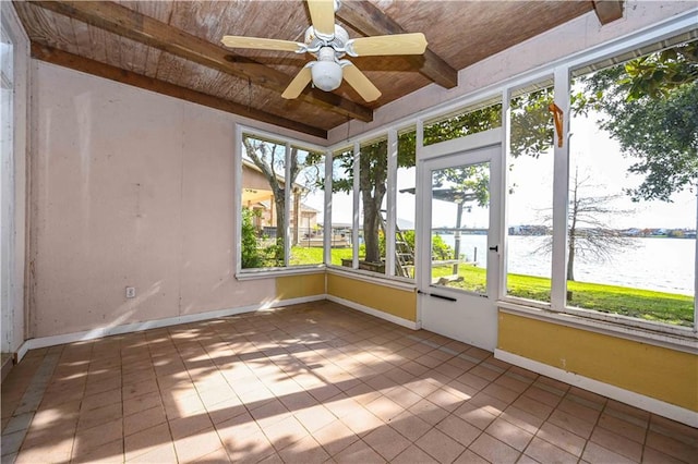 unfurnished sunroom featuring ceiling fan, beam ceiling, and a water view