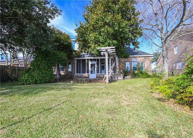 rear view of property with a sunroom and a lawn