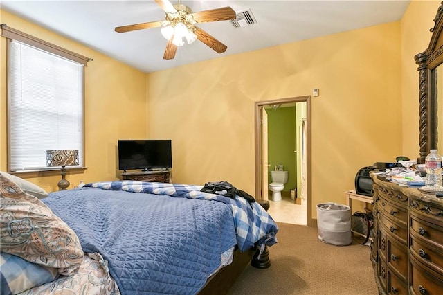 bedroom with connected bathroom, light carpet, and ceiling fan