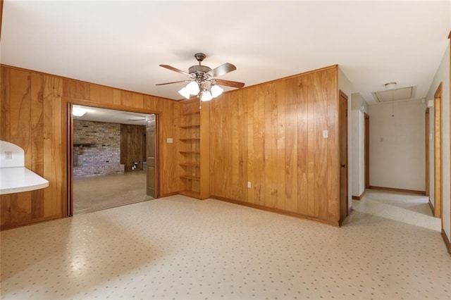 spare room featuring wood walls and ceiling fan