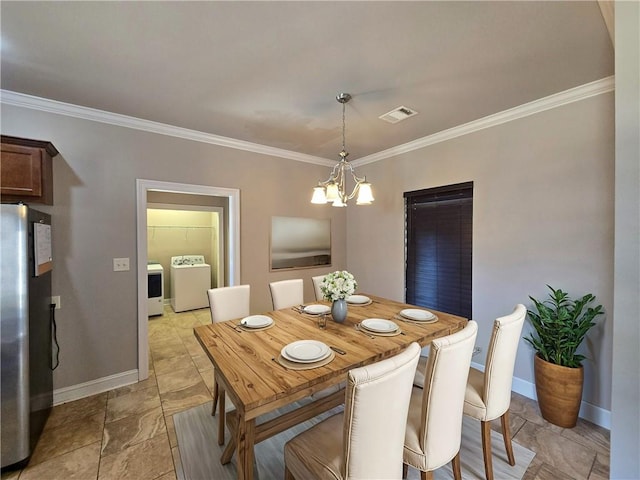 dining space featuring an inviting chandelier, crown molding, and washer and clothes dryer