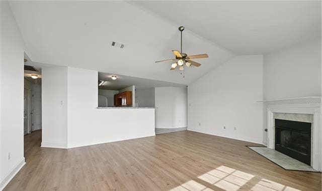 unfurnished living room featuring ceiling fan, light wood-type flooring, and vaulted ceiling