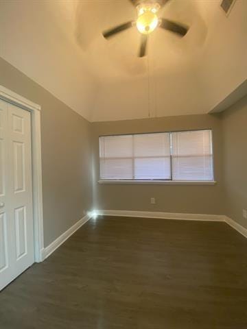 empty room featuring lofted ceiling, ceiling fan, and dark wood-type flooring