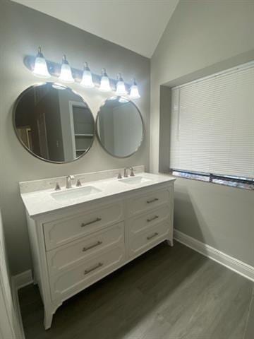 bathroom featuring vanity, hardwood / wood-style flooring, and lofted ceiling