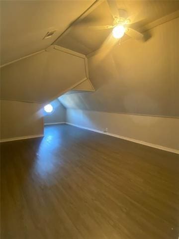 additional living space with ceiling fan, vaulted ceiling, and dark wood-type flooring