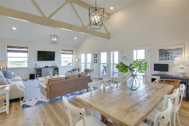 dining room with high vaulted ceiling, beam ceiling, light hardwood / wood-style flooring, french doors, and a notable chandelier