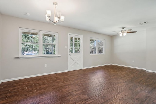 spare room featuring ceiling fan with notable chandelier and dark wood-type flooring