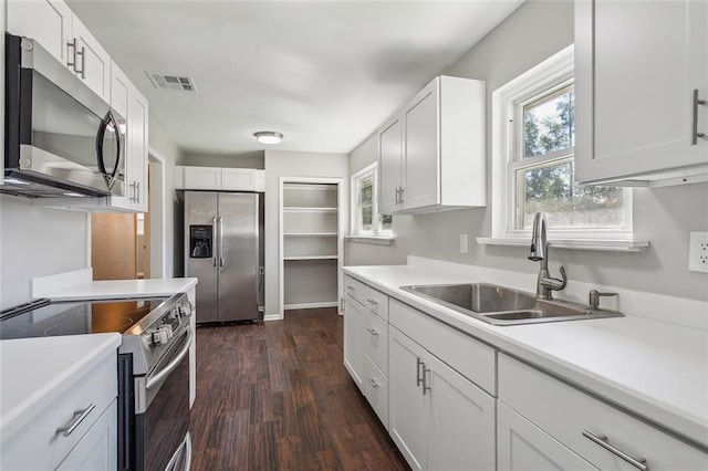 kitchen featuring stainless steel appliances, white cabinetry, dark hardwood / wood-style floors, and sink