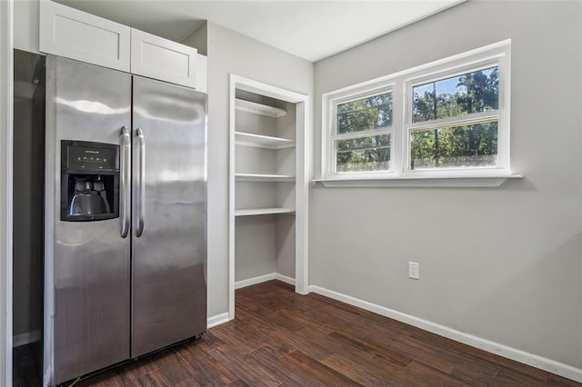 kitchen with white cabinets, dark hardwood / wood-style floors, and stainless steel fridge