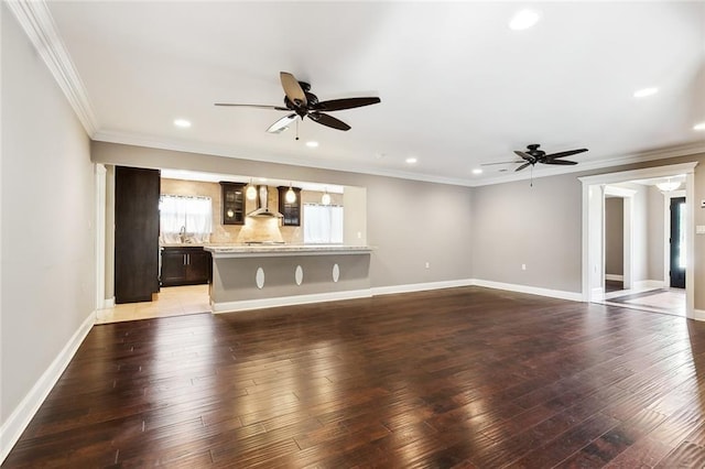 unfurnished living room with ceiling fan, ornamental molding, and dark hardwood / wood-style floors