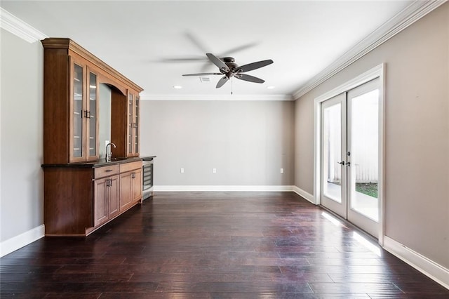 unfurnished living room featuring sink, ornamental molding, and french doors