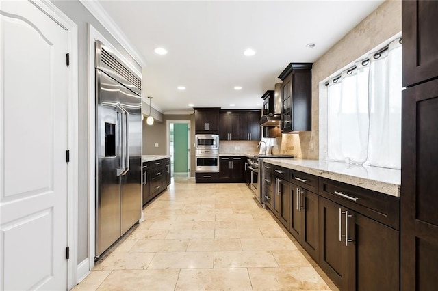 kitchen with decorative light fixtures, backsplash, built in appliances, crown molding, and dark brown cabinets