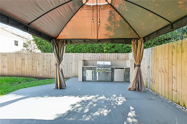 view of patio featuring exterior kitchen, a gazebo, and area for grilling