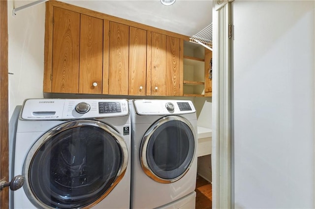 laundry area with cabinets and washing machine and clothes dryer