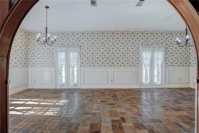 foyer with ornamental molding and an inviting chandelier