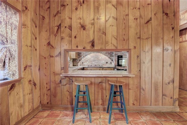 bar with wood walls and tile counters