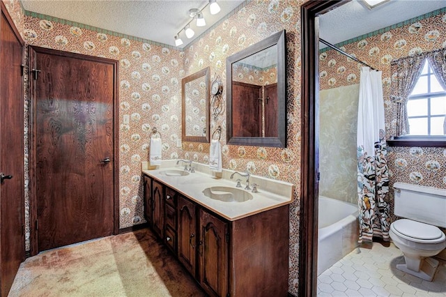 full bathroom featuring shower / bath combo with shower curtain, vanity, a textured ceiling, tile patterned flooring, and toilet