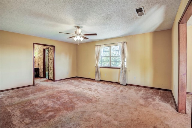 unfurnished room with a textured ceiling, ceiling fan, and light colored carpet