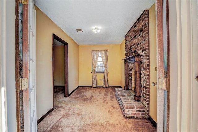 hall featuring a textured ceiling and light carpet