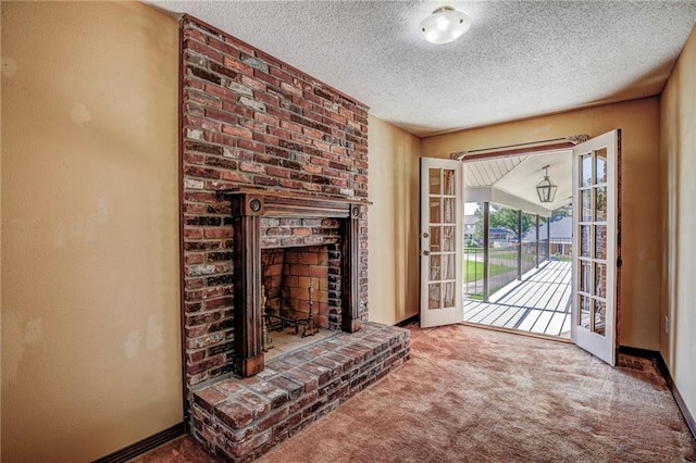 carpeted living room featuring a brick fireplace, a textured ceiling, and french doors